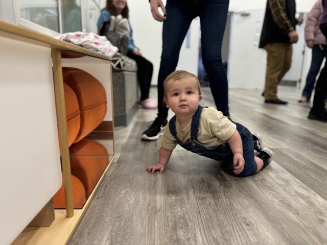 Small child crawling on floor of gym