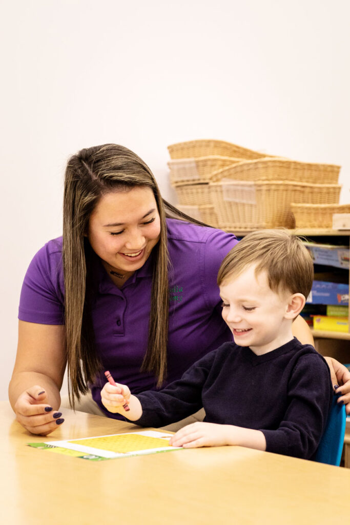 Teacher and school age boy working on a word puzzle