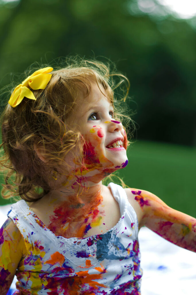 Girl painting outside during summer camp