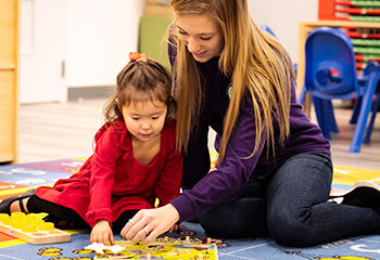 Teacher building a puzzle with a child