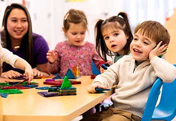 Teacher playing with two girls and boy